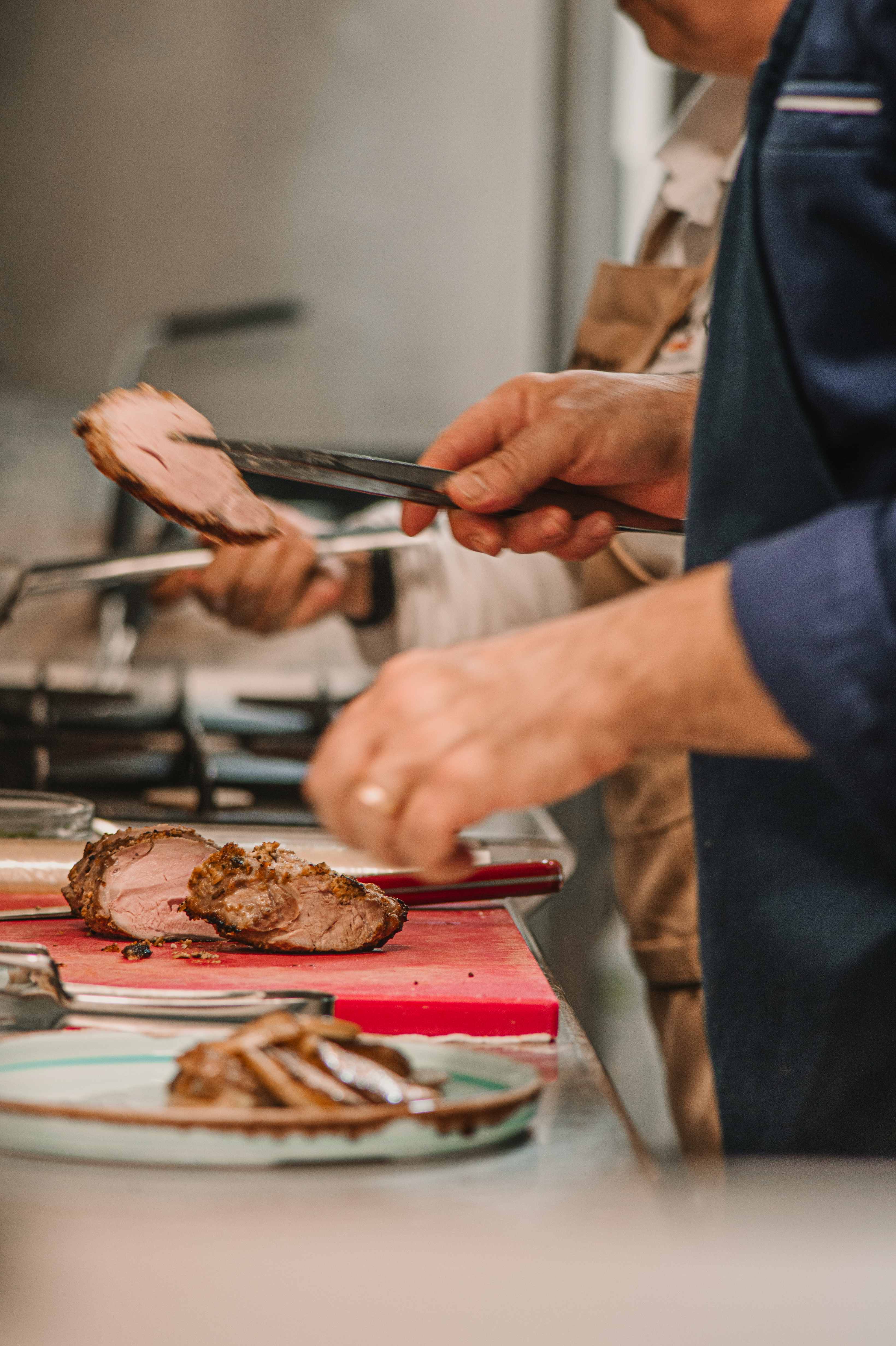 Chef che taglia carne in cucina